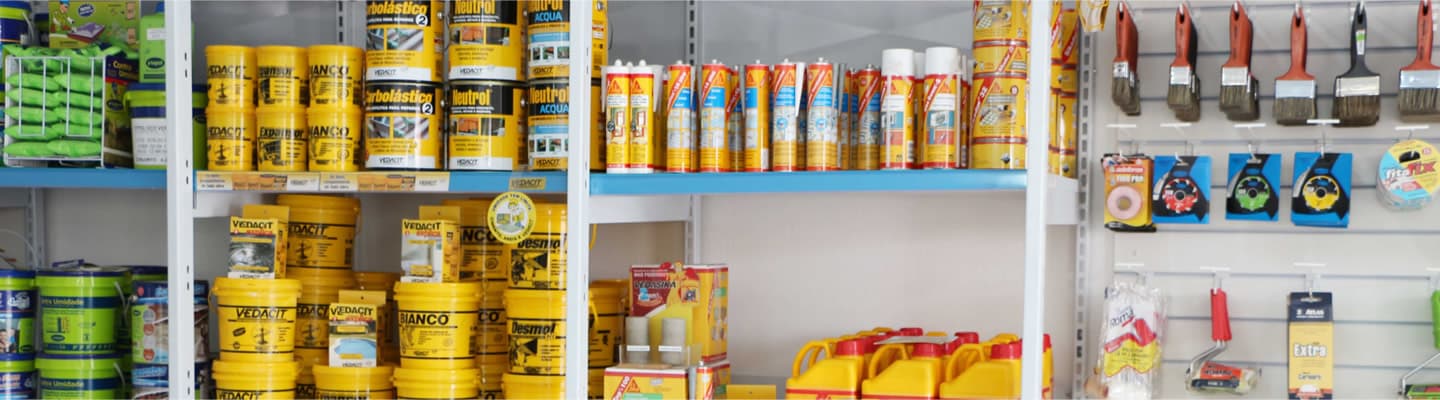 Prateleiras da loja Impercid com impermeabilizantes Vedacit, Sika e Quartzolit